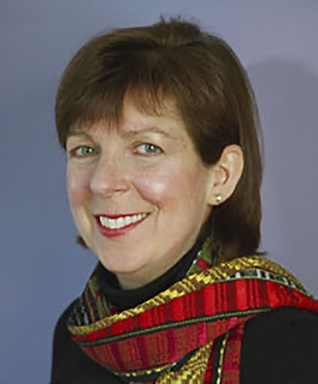 A head shot of a middle aged woman with short hair and wearing a red scarf